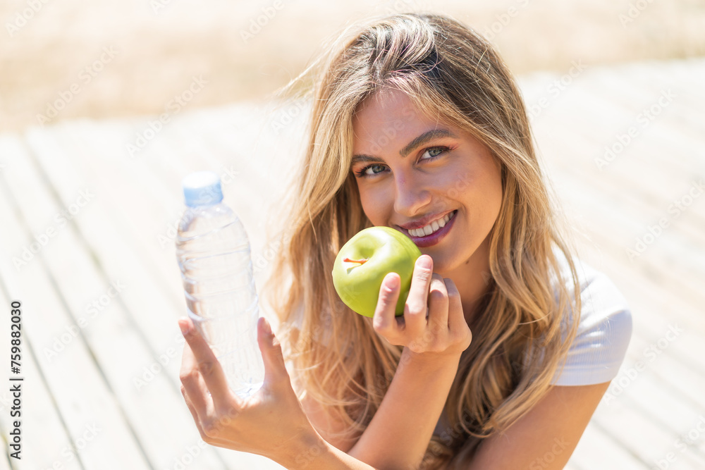 Pretty blonde Uruguayan woman with an apple and with a bottle of water Pretty blonde Uruguayan woman with an apple and with a bottle of water