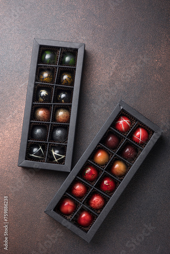 Box of assorted chocolates on dark background. Top view.