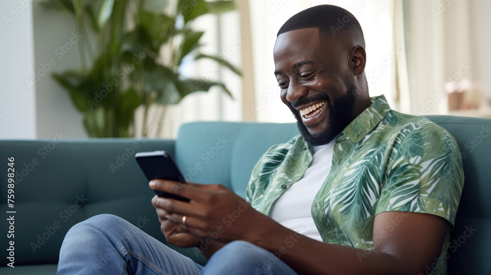 Happy man using a smartphone while comfortably seated on a couch Happy man using a smartphone while comfortably seated on a couch