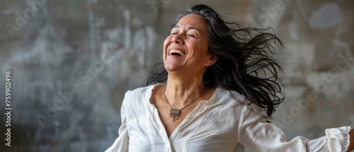 Middle-aged Hispanic dancer laughing joyously mid-twirl, her passion for dance infectious photo