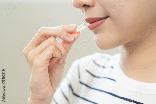 Woman taking daily supplement for vitamin