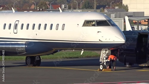 Private Jet Generic Unmarked Handling Airport Worker Applies Parking Blocks photo