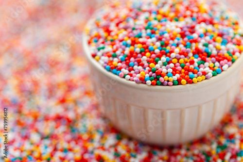Confectionery sprinkles in bowl. Colorful background. Decoration for cake and bakery.