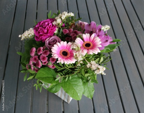Fototapeta Naklejka Na Ścianę i Meble -  Bunte Blumen als Geschenk arrangiert auf Tisch aus Holz