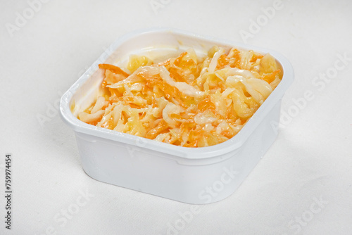 Coleslaw salad in plastic container bowl isolated on white background