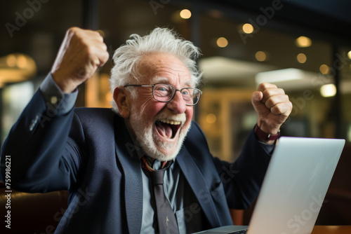 Joyful Senior Man Celebrating Success with Laptop in Office