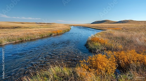 A bubbling stream flows through golden meadows. Concept: changing seasons, nature and active recreation, tourist routes and autumn holidays.