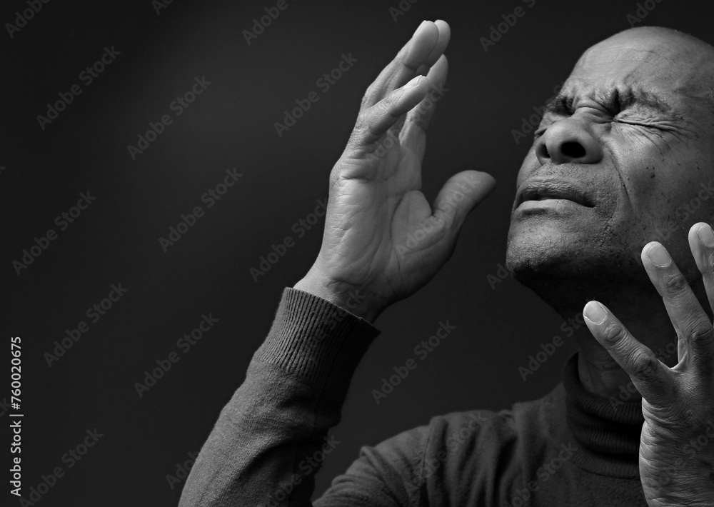 black man praying to god with hands together Caribbean man praying wit people stock image stock photo - obrazy, fototapety, plakaty 