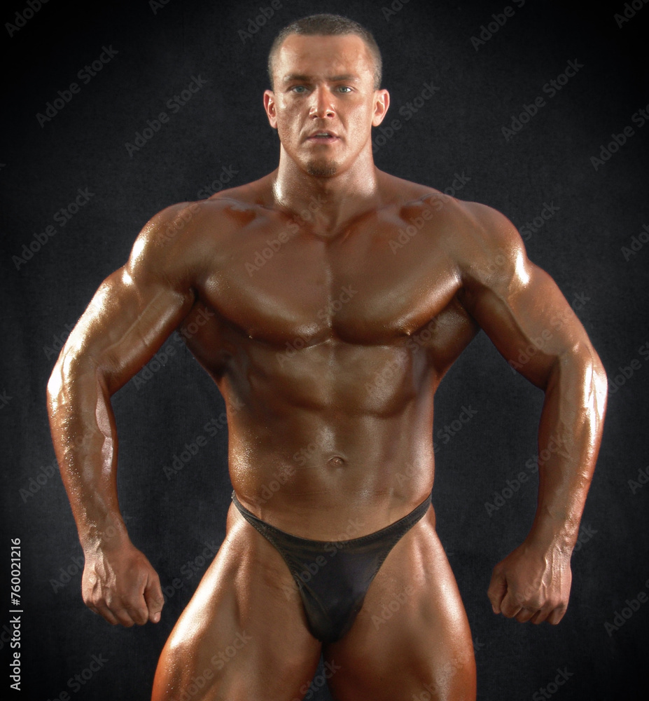 Portrait of a muscular male bodybuilder on a dark background.