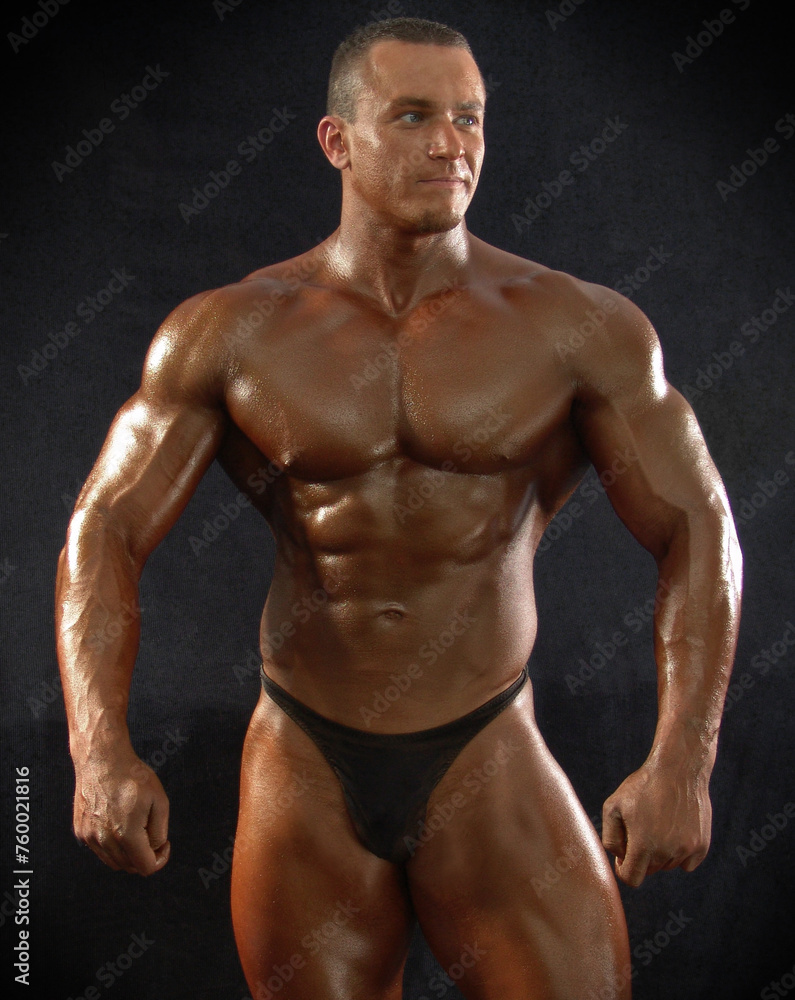 Portrait of a muscular male bodybuilder on a dark background.