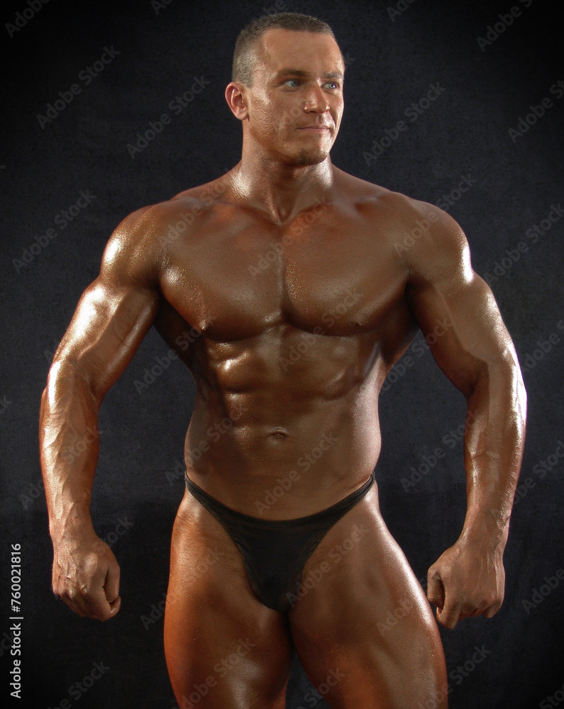 Portrait of a muscular male bodybuilder on a dark background. Portrait of a muscular male bodybuilder on a dark background.