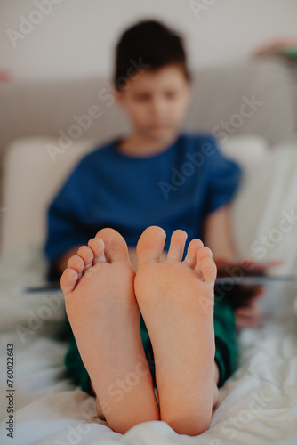 Boy is reading in the bedroom on the bed