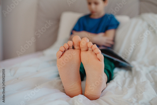 Boy is reading in the bedroom on the bed