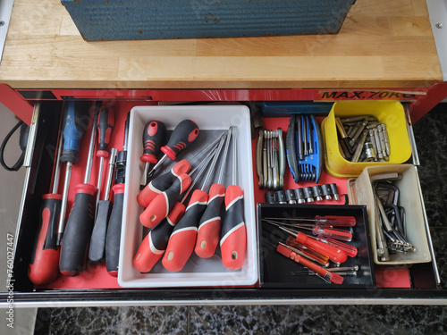 Detail of the open screwdriver drawer of the small tool cart in the apartment