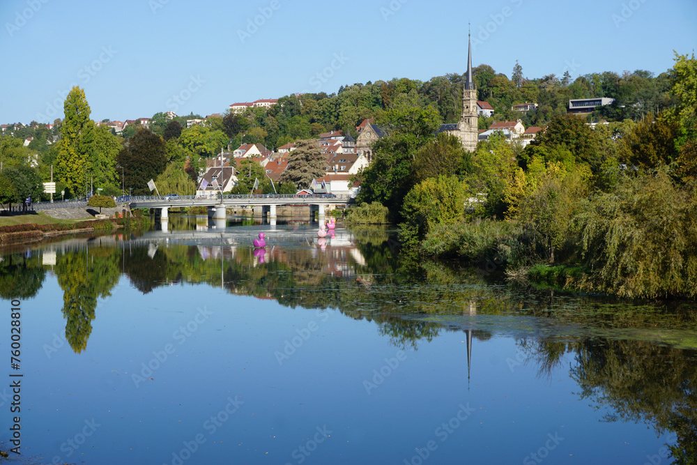 Fototapeta premium mirror reflection of the bridge, village and forest in the river in eastern france