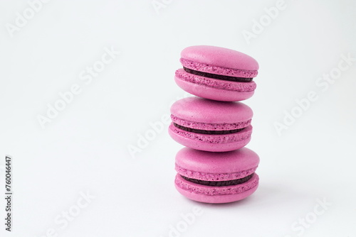 Pink French macaroons dessert on white background isolated. Sweet handmade almond macarons with chocolate filling for breakfast or Birthday, coffee break. Close up. © Foodie Studio