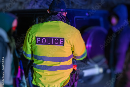 A police officer stands with his back to the car he stopped for speeding. stock photo