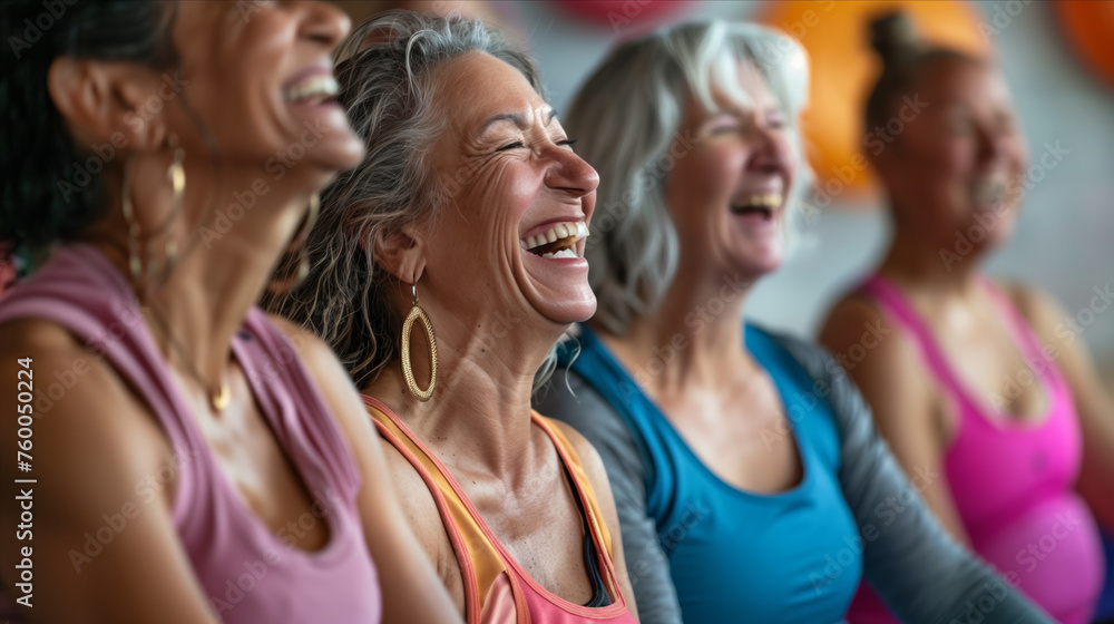 Elderly women laughing and sitting together in yoga studio.
