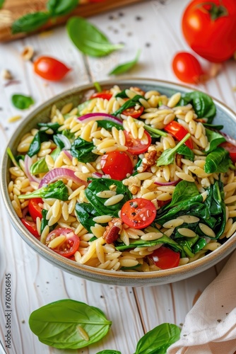 Delicious Bowl of Orzo with Spinach and Tomatoes on a Wooden Table