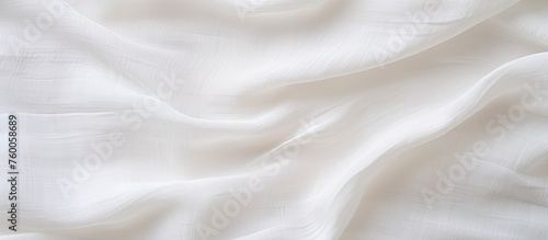 A detailed shot of a white cloth displaying wave patterns, resembling fur. The material is transparent, creating a peachcolored hue, perfect for event flooring or paper design