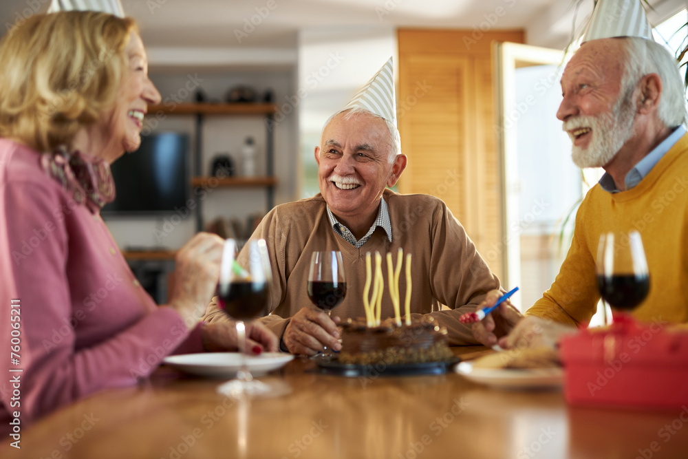 Fototapeta premium Group of happy senior friends having fun on a Birthday party at home