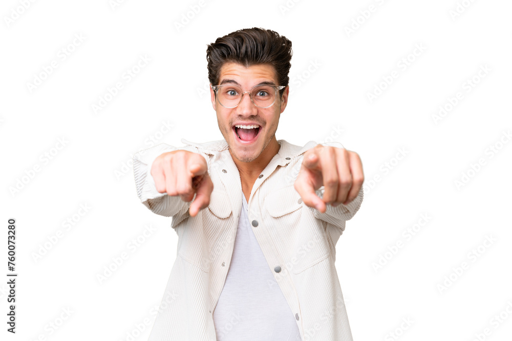 Young handsome caucasian man over isolated background surprised and pointing front Young handsome caucasian man over isolated background surprised and pointing front