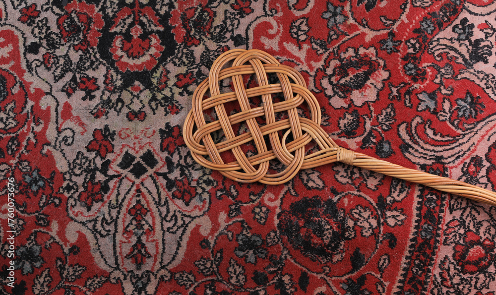 Φωτογραφία rattan beater on dirty carpet