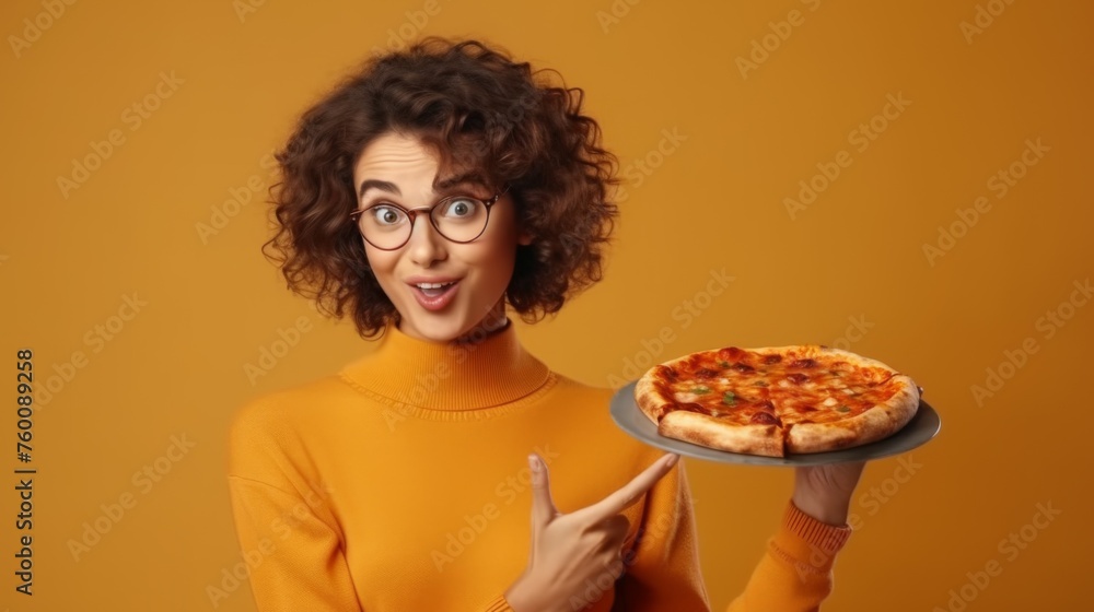 A young woman with curly glasses points at a pizza with a quirky expression, emphasizing fun and taste on an orange backdrop A young woman with curly glasses points at a pizza with a quirky expression, emphasizing fun and taste on an orange backdrop