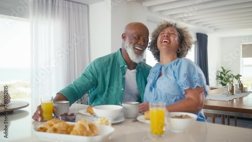Mature couple on vacation or at home eating breakfast together - shot in slow motion photo