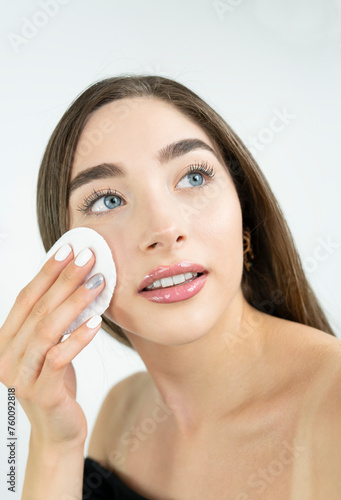 Beautiful blonde woman removing makeup from her face