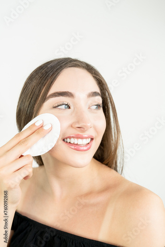 Beautiful blonde woman removing makeup from her face