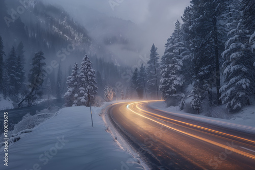Road in winter forest in the mountains illuminated by passing cars with headlights on, view from above