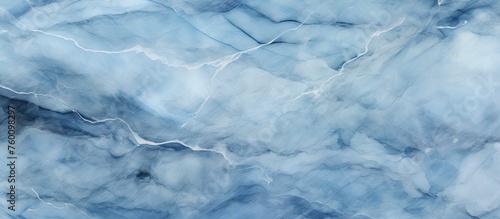 A close up image showcasing the fluid pattern of a blue marble texture, resembling the natural landscape of an ocean frozen in time, with hints of electric blue and wind waves