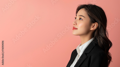 Asian businesswoman in black formal suit smiling isolated on pastel