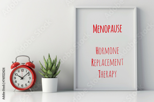 A red alarm clock sitting next to a poster, text Menopause, Hormone Replacement Therapy. photo