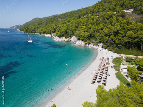 Foto White sandy beach with blue ocean lagoon and yacht moored