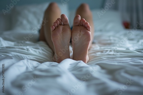 Ruhepause: Frauenfüße im Bett aus der Unteransicht
