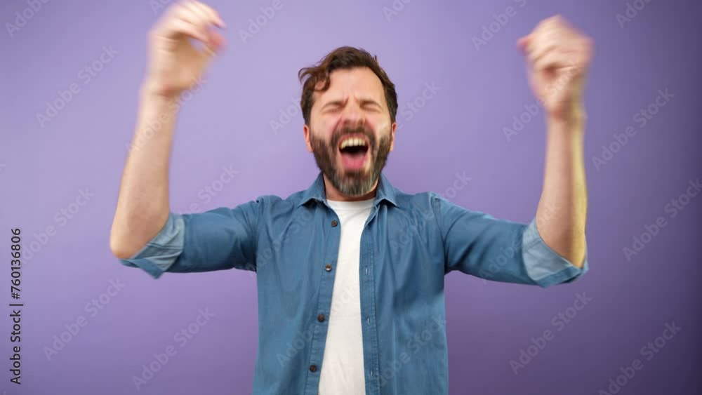 Joyful man celebrating success with arms raised in a studio Joyful man celebrating success with arms raised in a studio