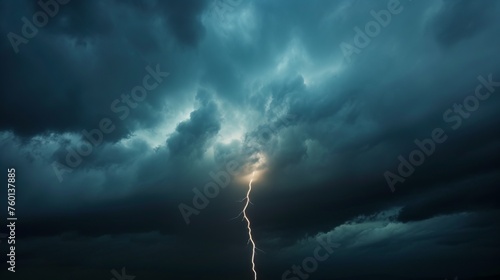 An atmospheric image showcasing a lone, bright lightning strike piercing through ominous dark storm clouds photo