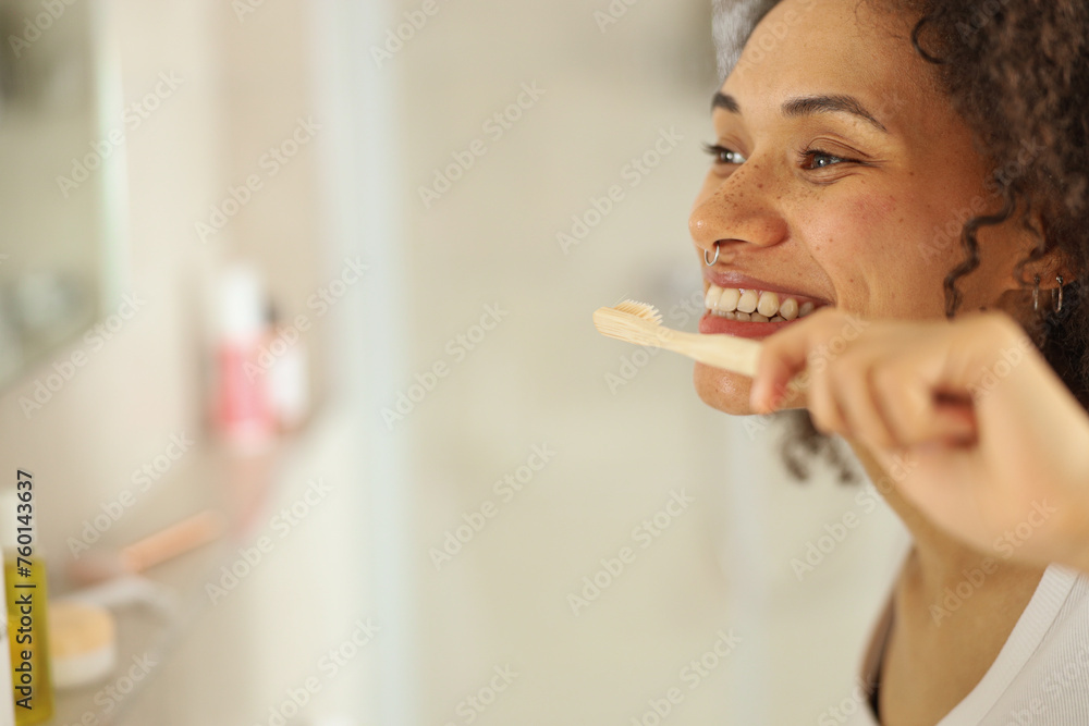 © Viktoria Kovalchuk - a woman is brushing her teeth in front of a mirror in a bathroom © Viktoria Kovalchuk - a woman is brushing her teeth in front of a mirror in a bathroom