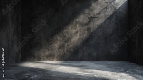 A corner of a dark room where a shaft of light creates an interplay of light and shadows on the walls photo