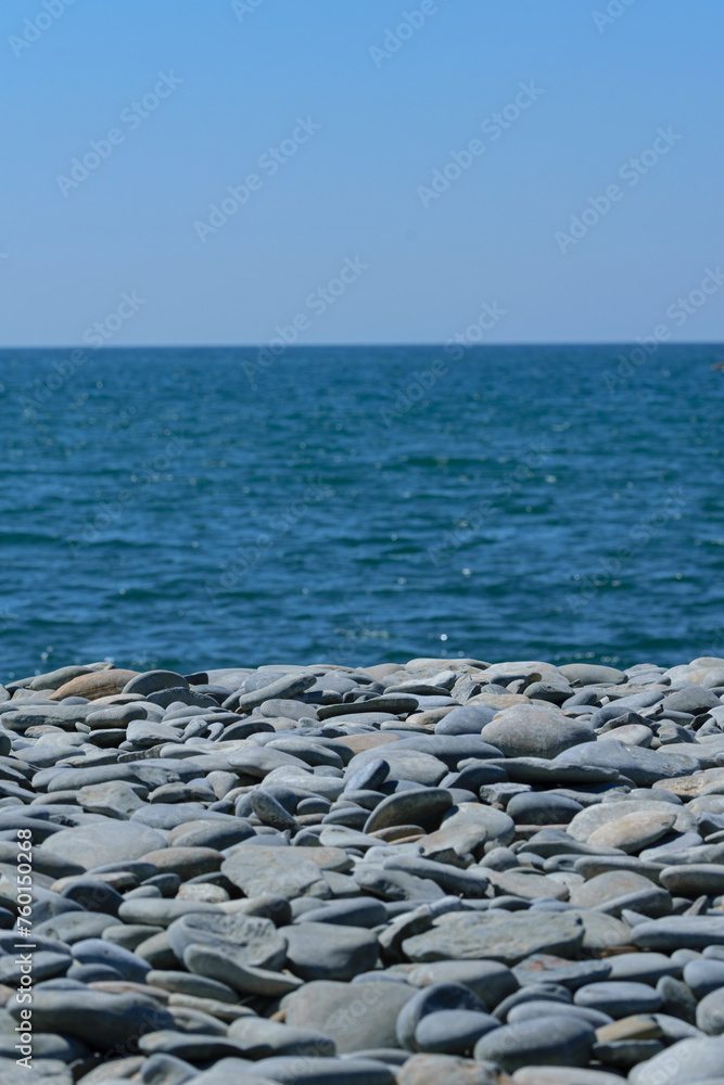 Gray stones on the seashore against the blue sky