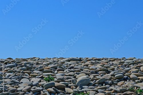 Obraz na płótnie Gray stones on the seashore against the blue sky w salonie