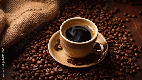 Aromatic steaming coffee in a cup surrounded by a plethora of roasted coffee beans on a wooden surface