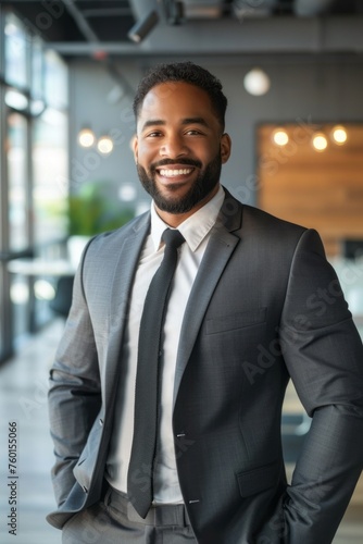 An accomplished business individual in formal attire  smiling confidently in a modern office interior  showcasing success and collaboration in a diverse corporate setting.