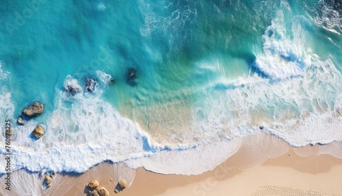 Aerial view of a paradise beach where the sea waves break on the shore. Top view of a beautiful sandy coast with turquoise blue water and white foam on sunny day. Summertime, traveling, holidays. © cabado