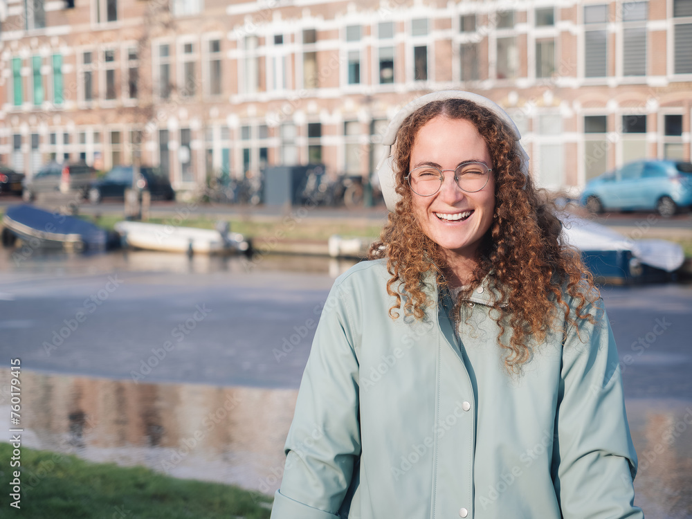 Joyful Curly-Haired Woman Smiling by the Canal