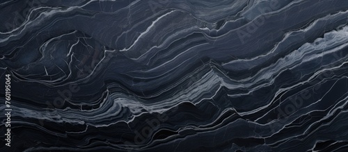 A detailed closeup of a fluid black and white marble pattern, resembling wind waves on water. The contrast of grey and electric blue creates a mesmerizing landscape, similar to wood grain