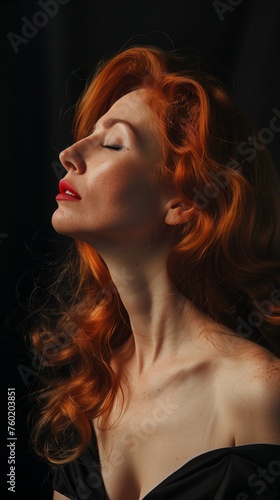 An attractive woman with red hair wearing a black dress.