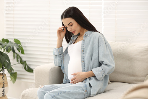 Pregnant young woman on sofa at home